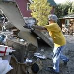 Barb Headrick throws damaged drywall into a pile while cleaning a flood damaged in Jamestown, Colorado on Sept. 28 2013.