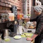 Barman making fruit juice drinks at a local vegan cafe.