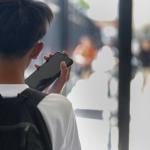 A young student uses mobile phone after unlocking it from secured usage during the school day.