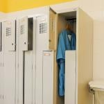 Only one of a row of metal lockers for nurses is occupied in a hospital illustrating staff shortage.