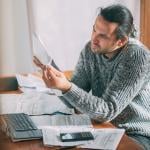 Homeowner looks at a power bill with confusion.