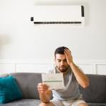 A homeowner is in distress looking at his energy bill.