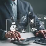 A business employee using a laptop illustrated with holographic concept icons of payroll and expense processes.