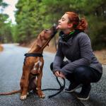 Rhodesian ridgeback gives owner a kiss on a hike.