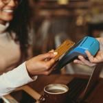 A woman taps her credit card in a restaurant's payment terminal.
