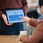 Cafe staff holding a tablet for additional tip options for customers.