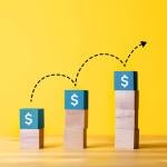 Concept of investment growth represented by an increasing stack of cubes with dollar signs.