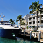 Luxury yacht docked in front of tropical waterfront condominiums