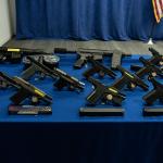 Confiscated guns on display at a press conference.