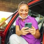 A happy travel nurse taking a break in her car.