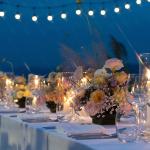 A wedding's dinner table reception outdoors during sunset.