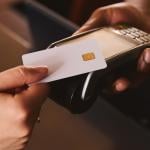 A credit card being tapped on a contactless payment terminal.
