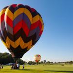 A colorful hot air balloon takes flight at a festival on a summer day in Plano, Texas.