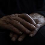 Hands of someone who is staying at a homeless shelter for domestic violence survivors, where funding cuts will impact services.