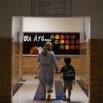 An English language teacher leads a student to their classroom at George Mason Elementary School in Alexandria, Virginia.