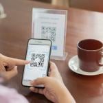 A customer scans a cafe's QR code for payment.