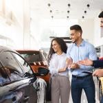Couple looking into purchasing a car in a dealer.