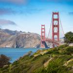 A stunning view of the Golden Gate Bridge surrounded by lush greenery and the calm waters of the San Francisco Bay.