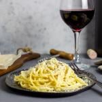 Roman pasta spaghetti cacio e pepe with black pepper, cheese, and wine.