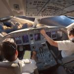 Cockpit of a modern passenger aircraft with pilots at work.