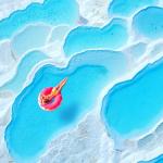 Person on pink inflatable donut in Travertine pools in Pamukkale, Turkey.