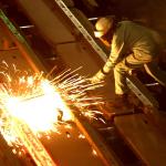 A worker cuts through a glowing 2,000 degrees Fahrenheit "billet" at the TAMCO steel mini mill