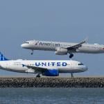 A United Airlines plane is taxiing to takeoff as an American Airlines plane lands at San Francisco International Airport