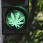 A traffic light with a green cannabis leaf.