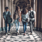 College students walking through an ornate hallway.