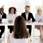 An applicant is interviewed by a board of four HR professionals.