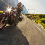 A person riding a motorcycle on a scenic mountain highway.