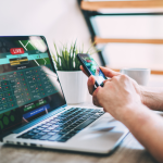 Close-up of a person placing sports bets on a laptop.