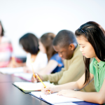 Students in a row taking a test.