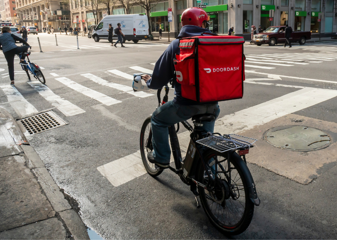 A delivery person with a DoorDash branded tote on his bicycle in the Chelsea neighborhood of New York.