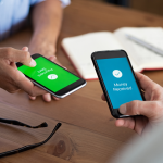 Two people using their mobile phones to send and receive money.