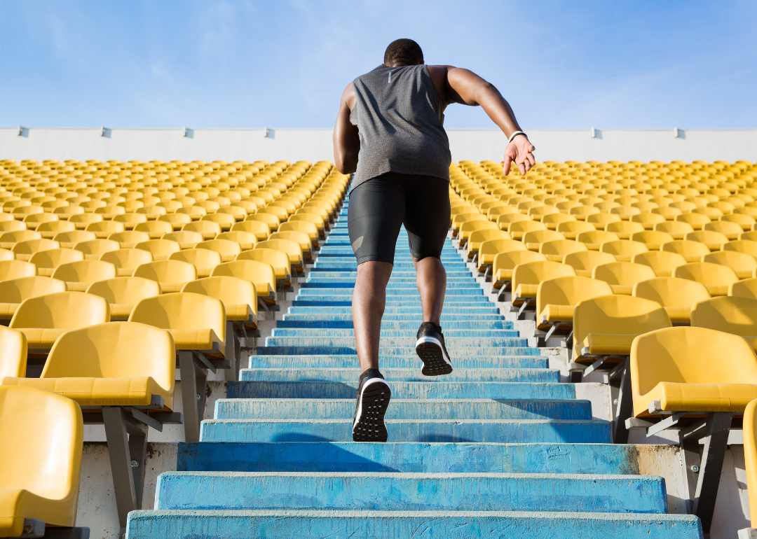 The back view of a young man running upstairs at a stadium