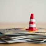 An orange cone on a stack of credit cards.