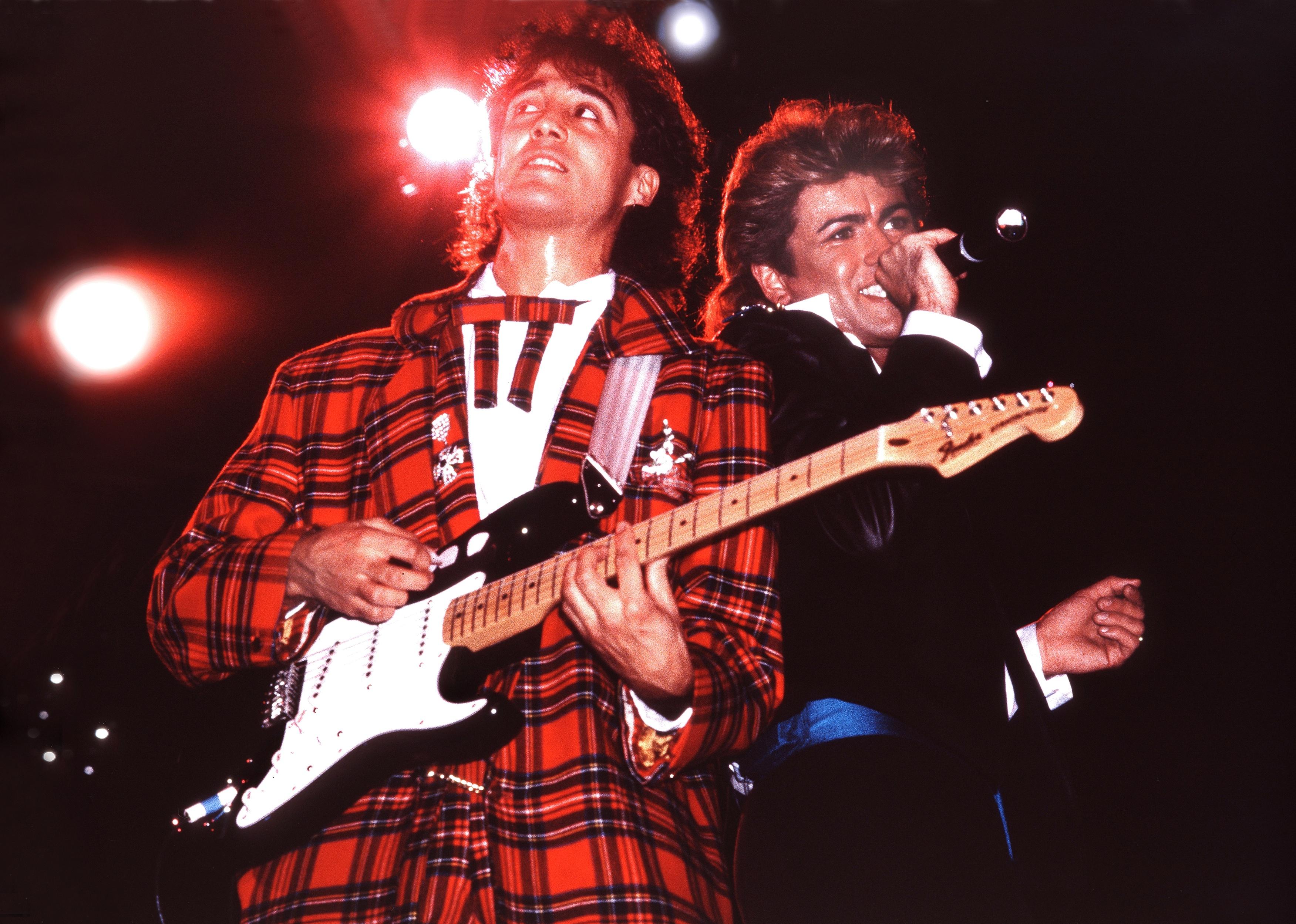 George Michael and Andrew Ridgeley performing on stage.