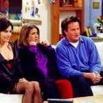 Courteney Cox, Jennifer Aniston and Matthew Perry sitting on the couch in Monica's living room in a scene from Friends. 