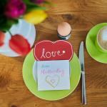 Aerial view of "Happy Mother's Day" and "love" in German on homemade cards