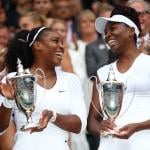 Venus Williams and Serena Williams hold up their trophies following victory in the Ladies Doubles Final