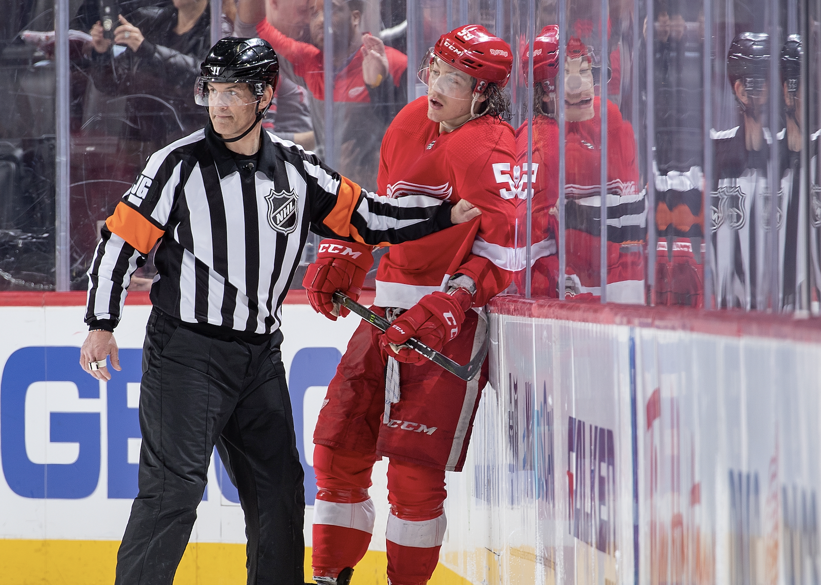 Referee holds back Tyler Bertuzzi of the Detroit Red Wings.