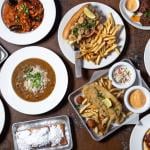 An overhead view of a table full of cajun creole dishes.