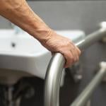 A person uses a bar in a bathroom.