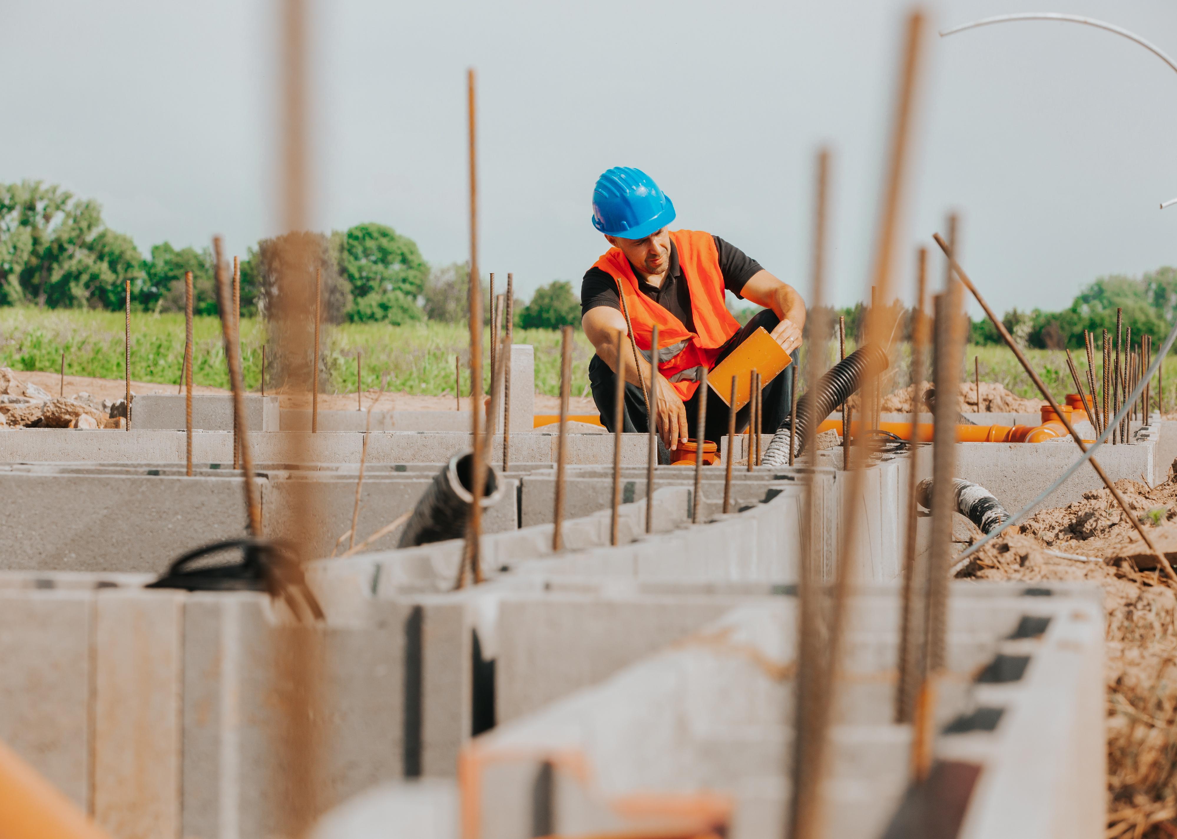 Builder looking at foundation of a house.