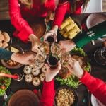 Top view of a group celebrating over a festive dinner table.