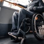 Person in a wheelchair on public transport with an accessible ramp.