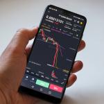 Smartphone with cyrptocurrency app screen in a man's hand.