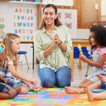 A teacher singing with her preschool children.