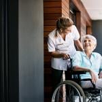 Health care worker talking to senior woman in wheelchair